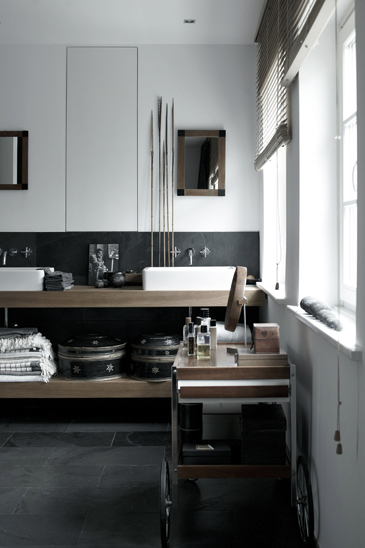 Badrumsinspiration - Danskt badrum med svart sten och mörkt trä. Stilleben, fönster och snygg serveringsvagn för badrumssaker.