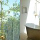 Badrumsinspiration - Utedusch i orangeri badrum med mässing och badkar på sockel