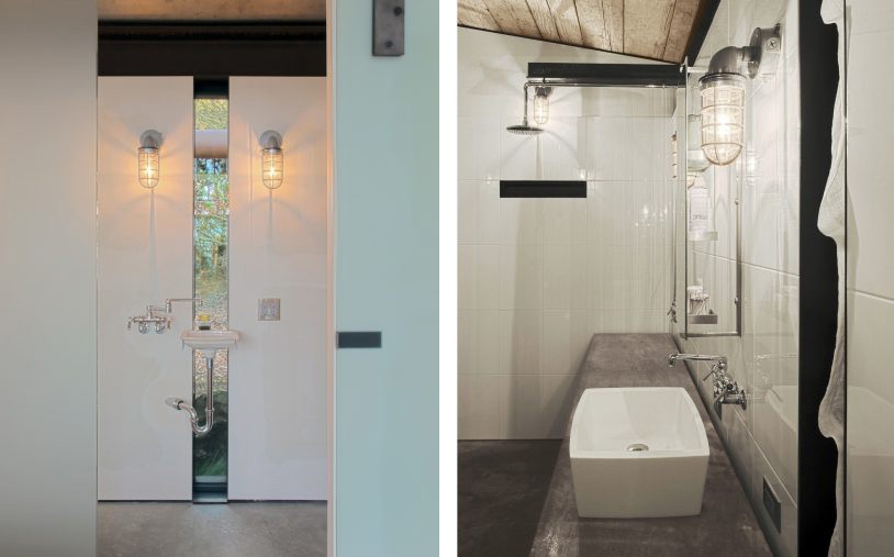 Badrumsinspiration - Industriellt badrum med betong, fristående badkar, spegelvägg, takfönster, badrumslampor med raster och synliga stålbalkar.