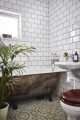 Badrumsinspiration - romantiskt badrum hemma hos Underbara Clara med rostigt badkar, spetsgardin och mönstrade klinker
