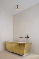 Badrumsinspiration - Minimalistiskt badrum med mässingbadkar i Antwerpen, Belgien.