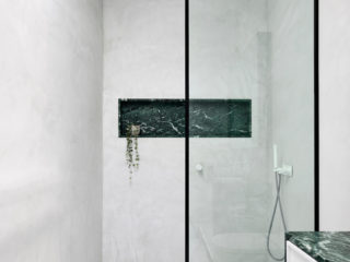 Badrumsinspiration - Snyggt badrum med tadelakt, grön marmor som detalj och vit marmor i chevron på golvet.