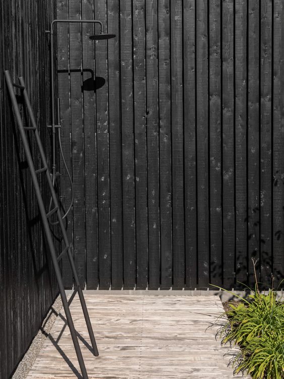Badrumsinspiration för sommardusch - Svart hus med svart utedusch och stege för handdukar.