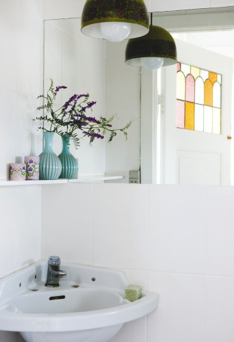 Badrumsinspiration - Liten charmig gästtoalett med hörntvättställ, vacker spegeldörr med färgat glas och avlång spegel