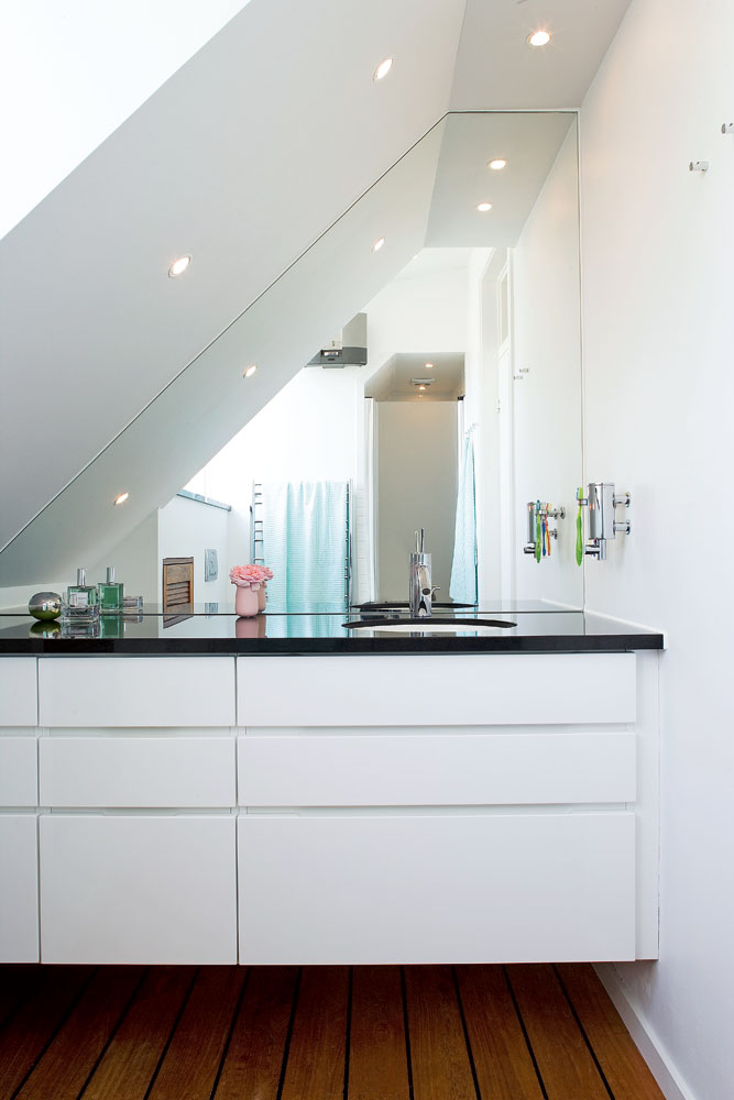 Badrumsinspiration - Litet vitt badrum med snedtak och platsbyggd badrumsmöbel med spegelvägg
