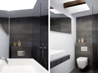Badrumsinspiration - Mörkgrå klinker och vita väggar i badrum med vägghängd toalett och takfönster.