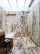 Badrumsinspiration - Flödig marmor i badrum med inbyggt badkar, marmortvättställ och takdusch i Selldorf Greenwich Village Townhouse