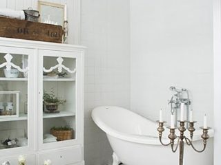 Badrumsinspiration - Vitt lantligt badrum med schachrutigt golv, tassbadkar och kristallkrona