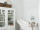 Badrumsinspiration - Vitt lantligt badrum med schachrutigt golv, tassbadkar och kristallkrona