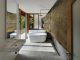 Badrumsinspiration - Ruffigt och kaxigt badrum med synliga stenblock, råa kopparrör och betong