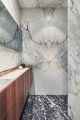 Badrumsinspiration - exklusitvt badrum med marmor, teakpanel, marmorbadkar och arkformade dörrar i Stockholm av Koncept