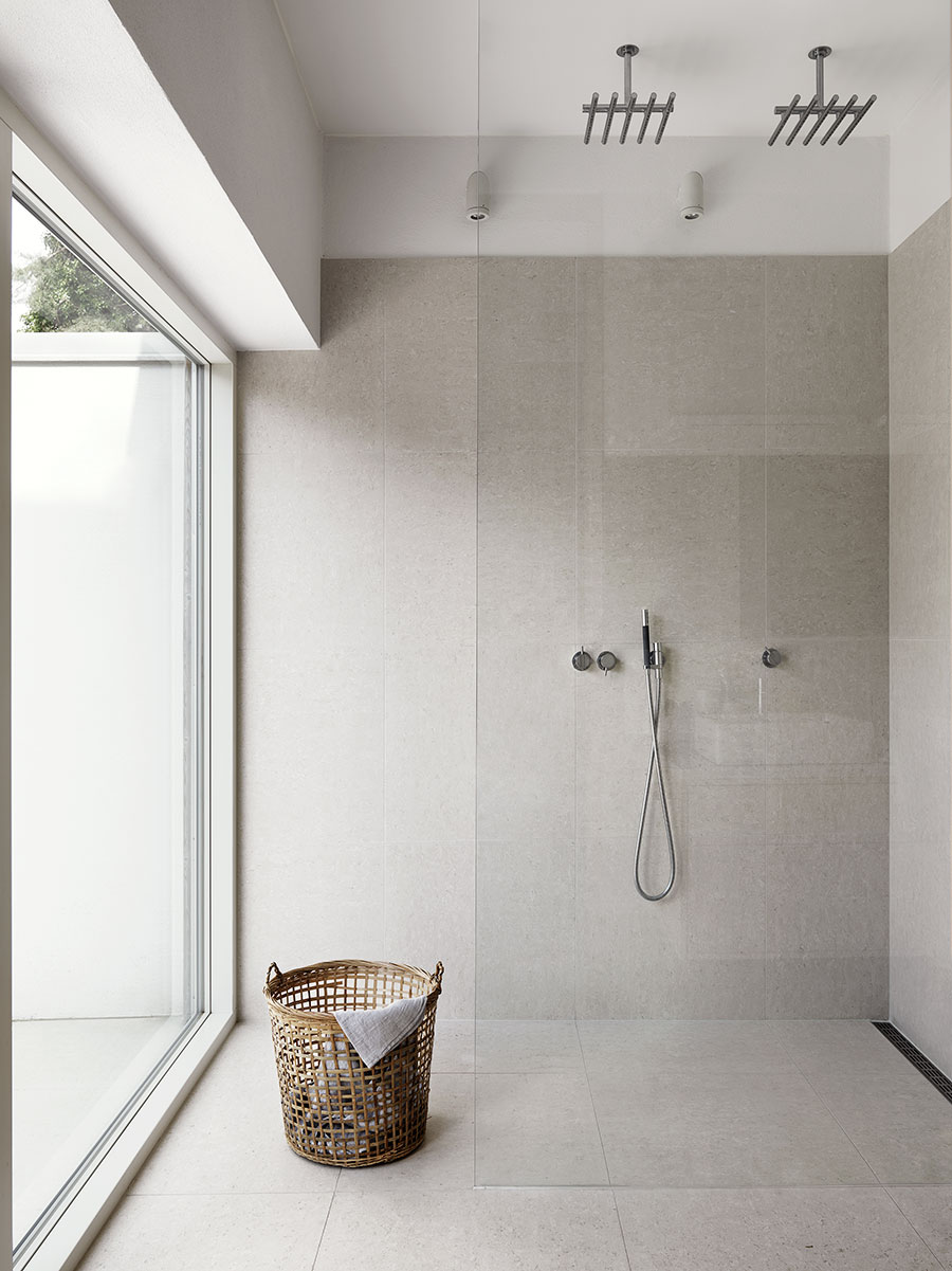 Badrumsinspiration - Naturnära badrum med sandstensliknande plattor och inbyggd dusch.