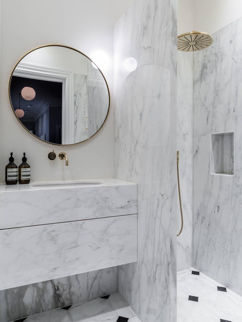 Badrumsinspiration - Carrara i badrum med marmormöbel, mässing, hyllnisch i dusch och oktagoner på golvet.