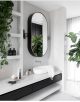 Badrumsinspiration - Modernt badrum med snygga spegelskåp, badrumslampor och mosaik och gröna växter.