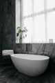 Badrumsinspiration - Grå marmor, äggformat badkar och rund spegel i badrum på Nobis Hotel Copenhagen ritat av Gert Wingårdh