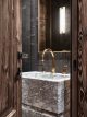 badrumsinspiration lyxigt badrum i alperna marmor guld stenhandfat badrumslampa chalet gstaad design Humbert Poyet foto Francis Amiand badrumsdrommar